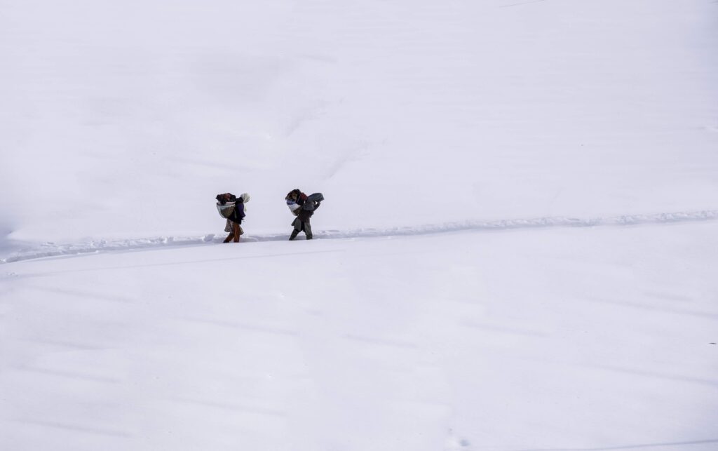 People trekking in the snowy mountains of Ladakh